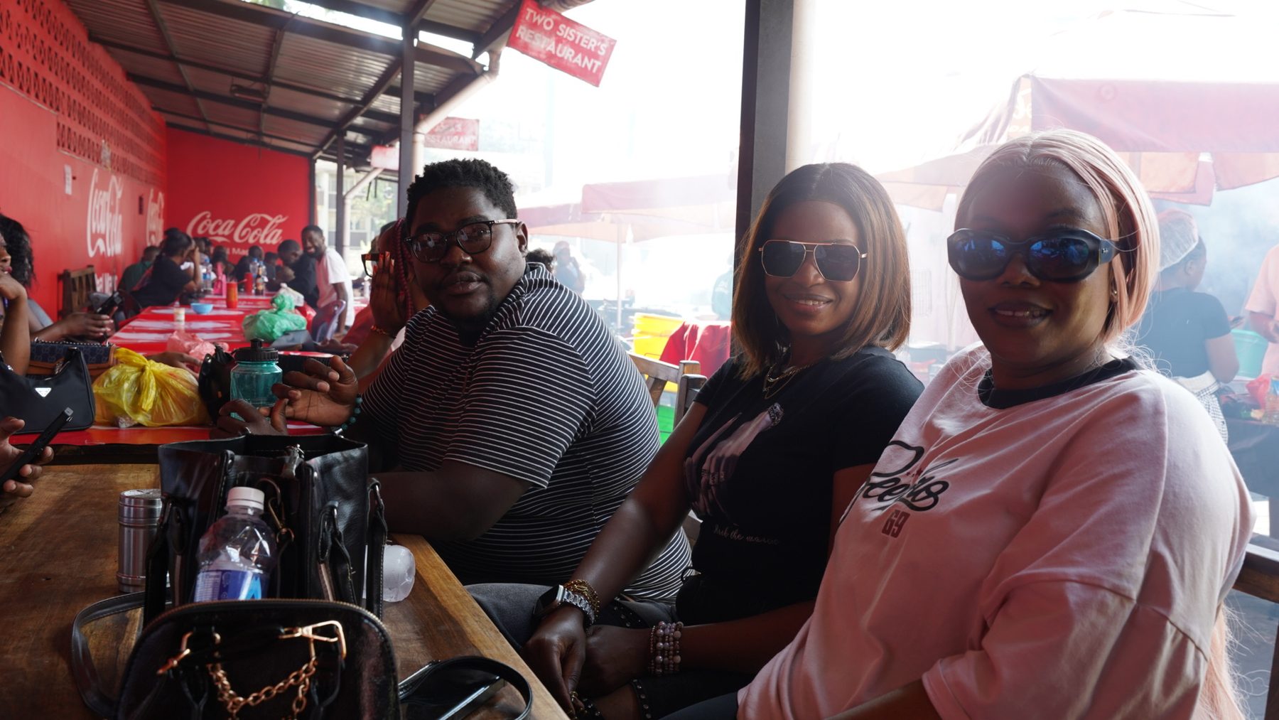 Group of travellers seated at a long table at a Lusaka grill market